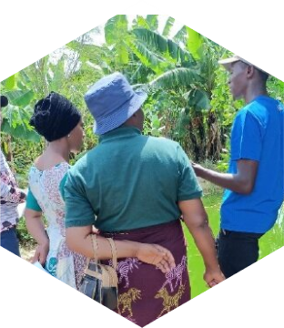 Man geeft bij centrum voor biologische landbouw in Tanzania uitleg over het onderhoud van een visvijver aan cursisten.
